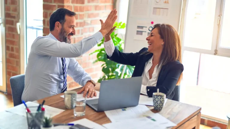 Male and female colleagues giving each other a high five